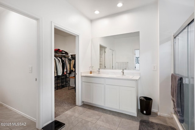3579 N Kellen Canyon Ct, Tucson, AZ 85745 - full bathroom with double vanity, a walk in closet, a shower stall, tile patterned flooring, and baseboards