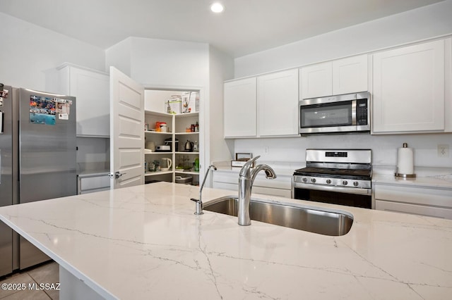 3579 N Kellen Canyon Ct, Tucson, AZ 85745 - kitchen with stainless steel appliances, a sink, white cabinets, light stone countertops, and recessed lighting