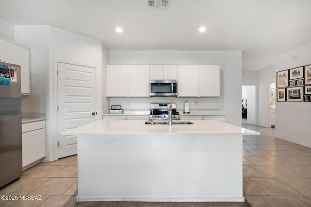 3579 N Kellen Canyon Ct, Tucson, AZ 85745 - kitchen featuring appliances with stainless steel finishes, a sink, a kitchen island with sink, white cabinetry, and light tile patterned floors