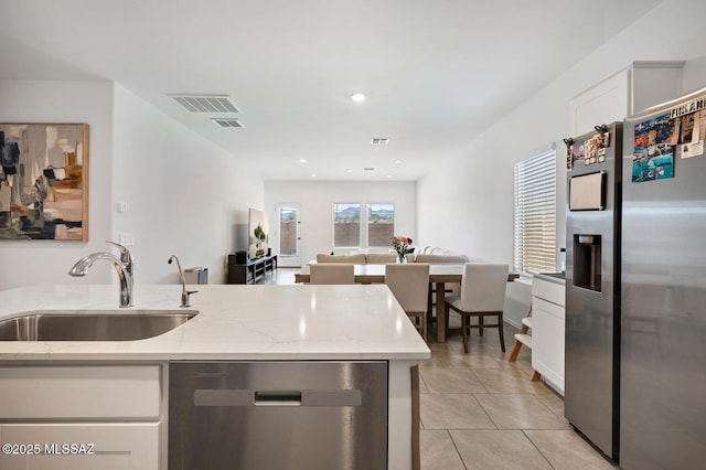 3579 N Kellen Canyon Ct, Tucson, AZ 85745 - kitchen with appliances with stainless steel finishes, a sink, open floor plan, white cabinetry, and light stone countertops