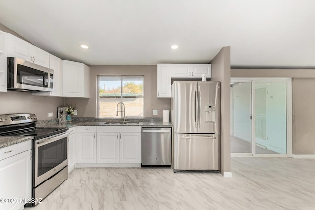 5541 E Mabel St, Tucson, AZ 85712 - kitchen featuring appliances with stainless steel finishes, white cabinets, dark stone countertops, recessed lighting, and light marble finish flooring