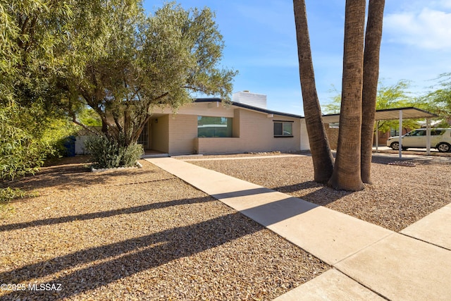 5541 E Mabel St, Tucson, AZ 85712 - view of front of home with a chimney, a carport, and brick siding