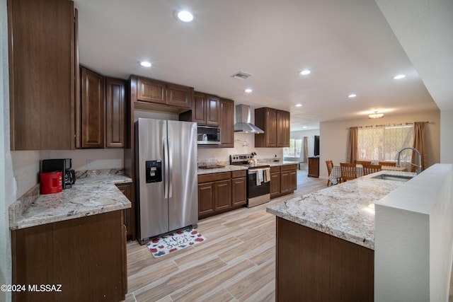 5617 N Camino Del Conde, Tucson, AZ 85718 - kitchen with appliances with stainless steel finishes, a sink, wall chimney exhaust hood, recessed lighting, and wood tiled floors