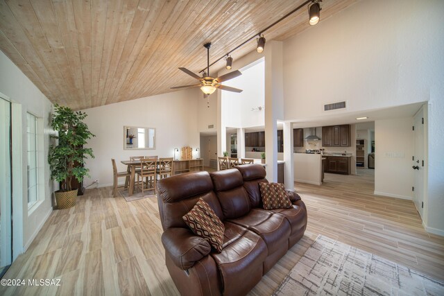 5617 N Camino Del Conde, Tucson, AZ 85718 - living area featuring track lighting, light wood-type flooring, a ceiling fan, baseboards, and high vaulted ceiling