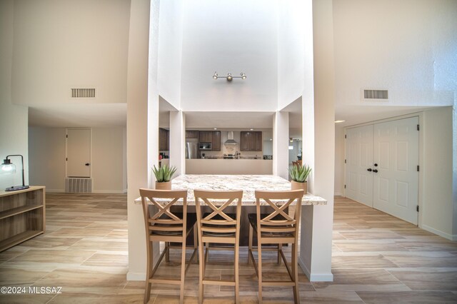 5617 N Camino Del Conde, Tucson, AZ 85718 - dining room with a high ceiling, baseboards, and light wood-style flooring