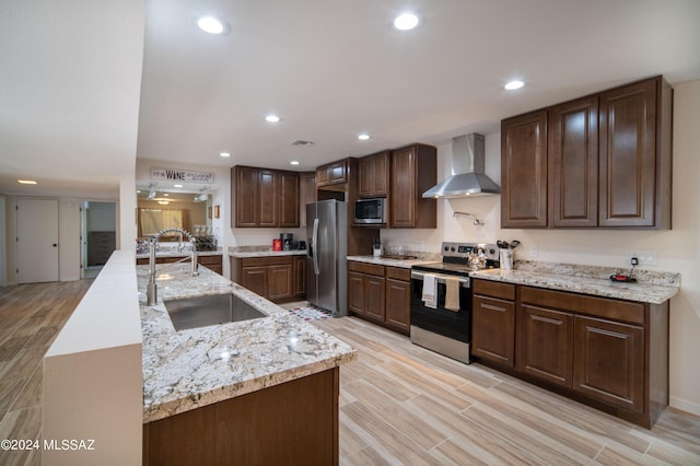 5617 N Camino Del Conde, Tucson, AZ 85718 - kitchen featuring wall chimney exhaust hood, stainless steel appliances, a sink, light wood finished floors, and recessed lighting