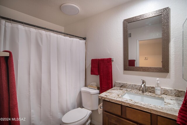 5617 N Camino Del Conde, Tucson, AZ 85718 - bathroom featuring toilet, vanity, a textured wall, and a shower with shower curtain