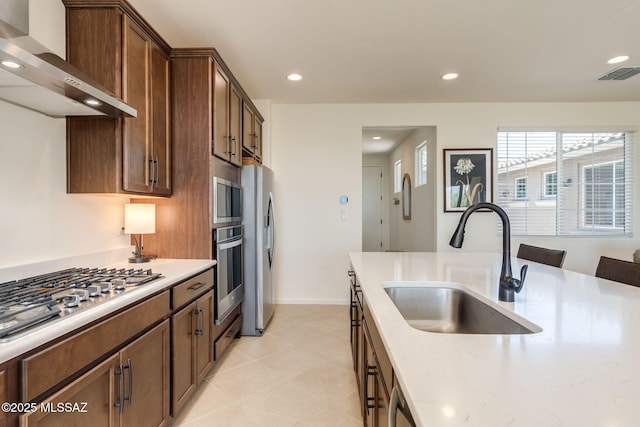 7823 W Buckeye Path, Marana, AZ 85658 - kitchen with wall chimney range hood, a sink, stainless steel appliances, recessed lighting, and light tile patterned floors