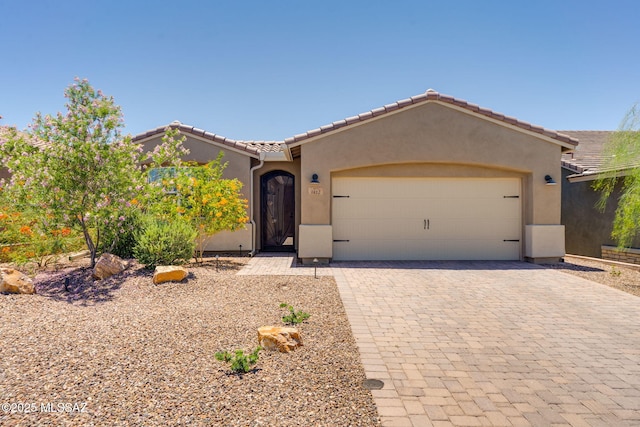 7823 W Buckeye Path, Marana, AZ 85658 - view of front of house with a garage, stucco siding, decorative driveway, and a tile roof