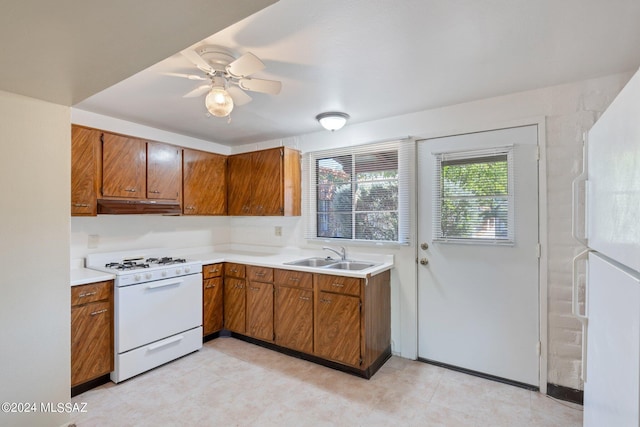 341 W Camino Penasco Apt B, Green Valley, AZ 85614 - kitchen featuring white gas range, under cabinet range hood, a sink, and brown cabinetry
