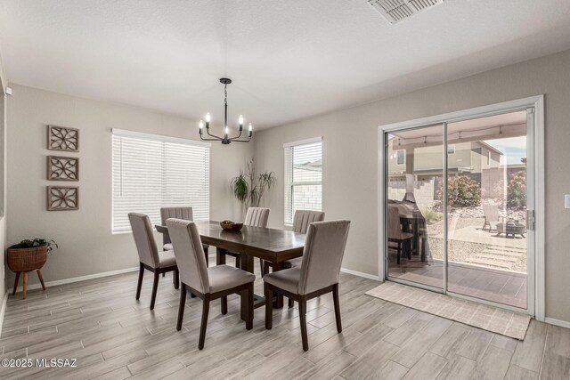 1257 W Calle Libro Del Retrato, Sahuarita, AZ 85629 - dining room with a chandelier, light wood finished floors, and baseboards