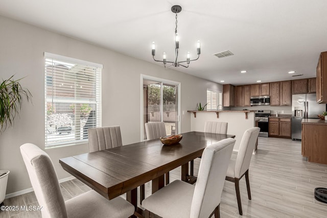 1257 W Calle Libro Del Retrato, Sahuarita, AZ 85629 - dining area with a chandelier, recessed lighting, light wood-type flooring, and baseboards
