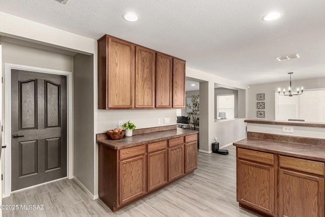 1257 W Calle Libro Del Retrato, Sahuarita, AZ 85629 - kitchen with dark countertops, baseboards, light wood finished floors, brown cabinetry, and recessed lighting
