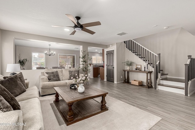 1257 W Calle Libro Del Retrato, Sahuarita, AZ 85629 - living area featuring stairway, a chandelier, ceiling fan, and wood finished floors