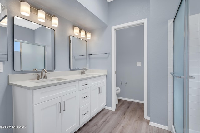4996 N Valle Rd, Tucson, AZ 85750 - full bathroom featuring double vanity, wood finished floors, toilet, and baseboards