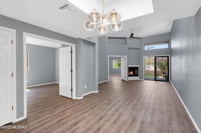 4996 N Valle Rd, Tucson, AZ 85750 - unfurnished living room featuring wood finished floors, baseboards, a lit fireplace, and a ceiling fan