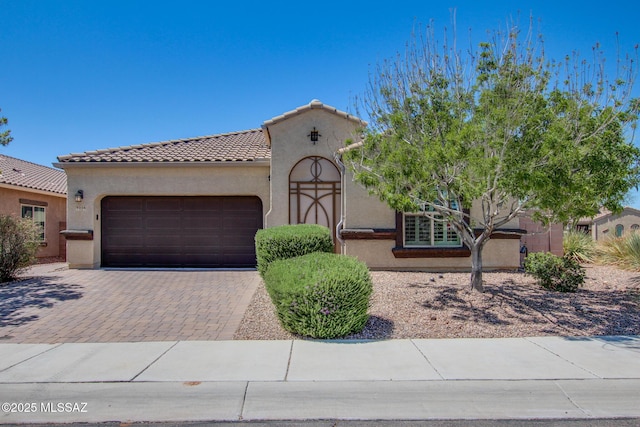 9016 W Birchover Dr, Marana, AZ 85653 - mediterranean / spanish-style home featuring an attached garage, stucco siding, decorative driveway, and a tile roof