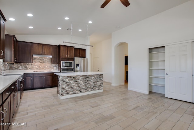 9016 W Birchover Dr, Marana, AZ 85653 - kitchen with stainless steel appliances, arched walkways, under cabinet range hood, ceiling fan, and dark brown cabinets