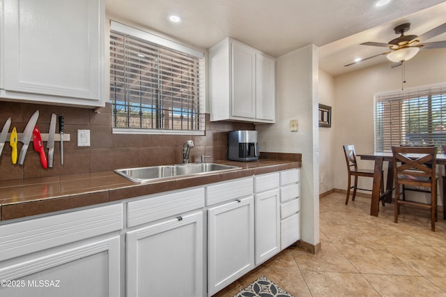 1410 W Sonora St, Tucson, AZ 85745 - kitchen featuring a sink, tasteful backsplash, white cabinetry, baseboards, and a ceiling fan