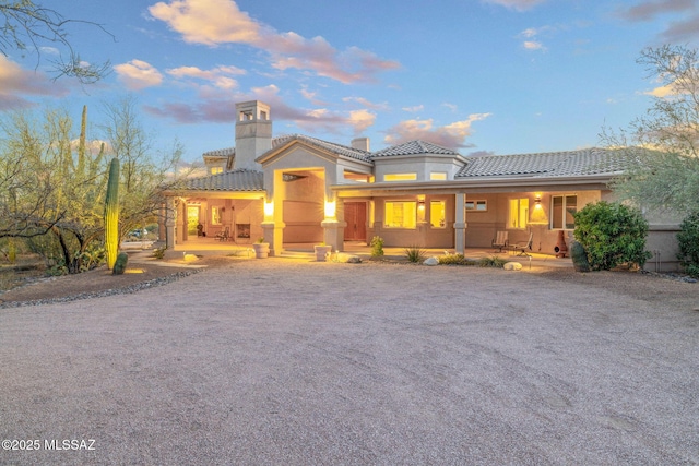 4141 W Camino Del Norte, Tucson, AZ 85742 - mediterranean / spanish home with covered porch, a tiled roof, stucco siding, and a chimney