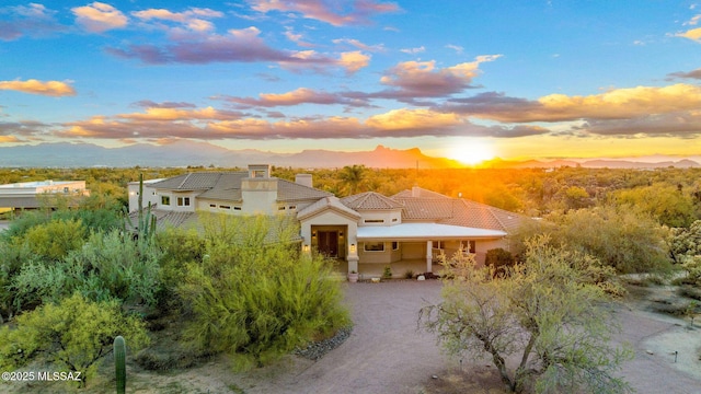 4141 W Camino Del Norte, Tucson, AZ 85742 - mediterranean / spanish house featuring a tiled roof, stucco siding, a chimney, and a mountain view