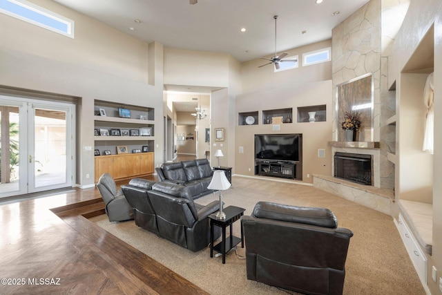 4141 W Camino Del Norte, Tucson, AZ 85742 - living area featuring a high ceiling, a premium fireplace, built in shelves, ceiling fan, and carpet flooring