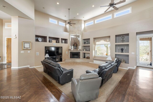 4141 W Camino Del Norte, Tucson, AZ 85742 - living area with ceiling fan, a high ceiling, a fireplace, built in features, and healthy amount of natural light