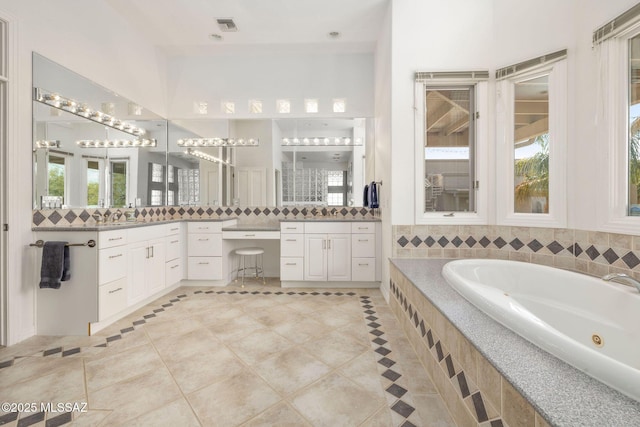 4141 W Camino Del Norte, Tucson, AZ 85742 - full bathroom featuring a tub with jets, backsplash, vanity, tile patterned flooring, and plenty of natural light
