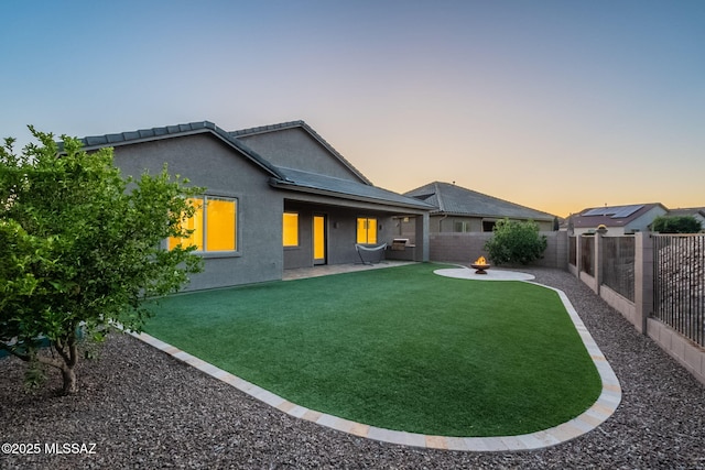 12584 N Sunrise Shadow Dr, Marana, AZ 85658 - back of house at dusk with stucco siding and a patio