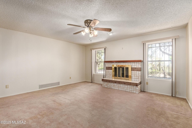 555 E Rudasill Rd, Tucson, AZ 85704 - unfurnished living room featuring ceiling fan, carpet floors, a tile fireplace, baseboards, and a textured ceiling