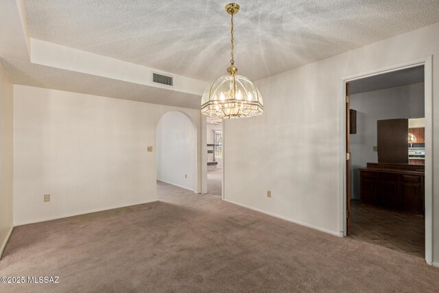 555 E Rudasill Rd, Tucson, AZ 85704 - spare room with arched walkways, carpet floors, a chandelier, a textured ceiling, and baseboards