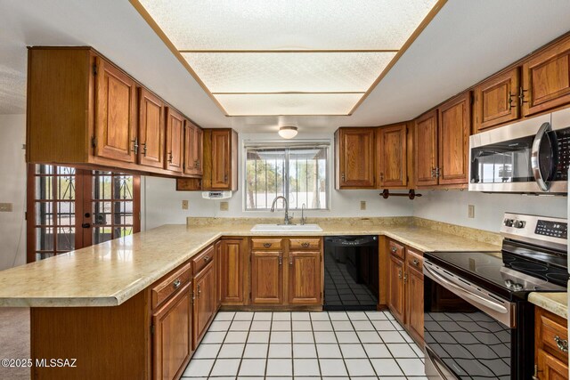 555 E Rudasill Rd, Tucson, AZ 85704 - kitchen featuring stainless steel appliances, a sink, a peninsula, brown cabinetry, and light countertops
