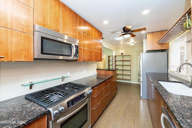 3225 E Elida St, Tucson, AZ 85716 - kitchen with appliances with stainless steel finishes, a sink, ceiling fan, light wood finished floors, and decorative backsplash
