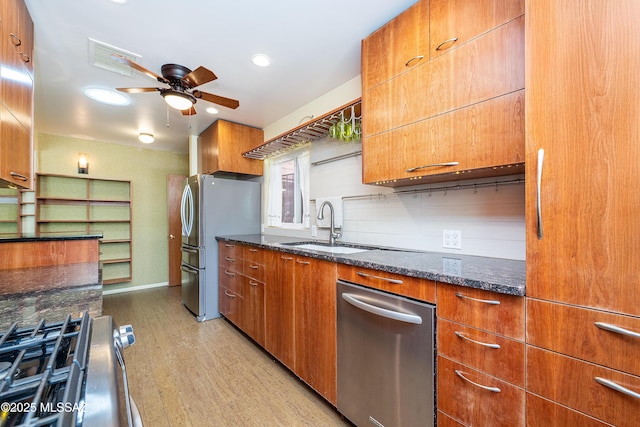 3225 E Elida St, Tucson, AZ 85716 - kitchen featuring stainless steel appliances, a sink, ceiling fan, dark stone counters, and light wood-style floors