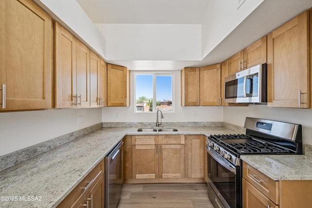 7112 S Haskins Dr, Tucson, AZ 85746 - kitchen featuring stainless steel appliances, a sink, light wood finished floors, and light stone counters