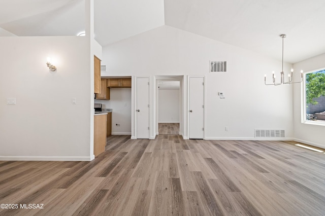 7112 S Haskins Dr, Tucson, AZ 85746 - unfurnished living room featuring a chandelier, high vaulted ceiling, light wood finished floors, and baseboards