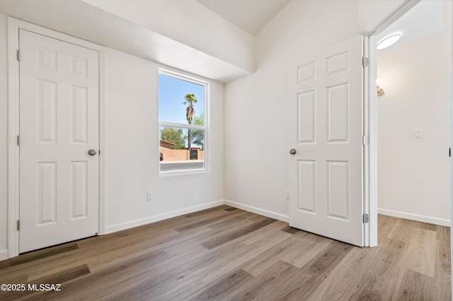 7112 S Haskins Dr, Tucson, AZ 85746 - unfurnished bedroom with wood finished floors and baseboards