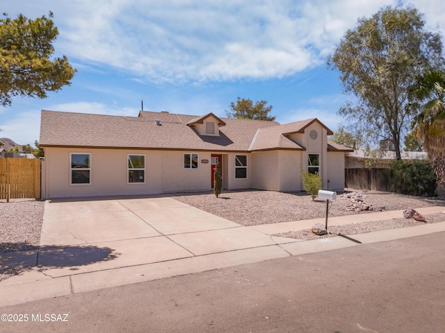 7112 S Haskins Dr, Tucson, AZ 85746 - view of front facade featuring stucco siding, roof with shingles, driveway, and a patio area