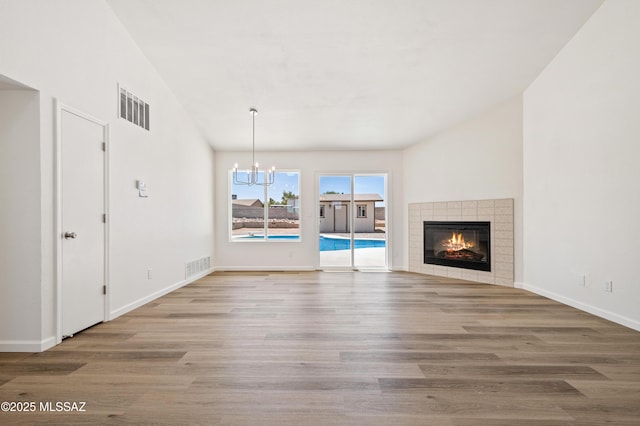 7112 S Haskins Dr, Tucson, AZ 85746 - unfurnished living room featuring a chandelier, wood finished floors, a fireplace, and baseboards