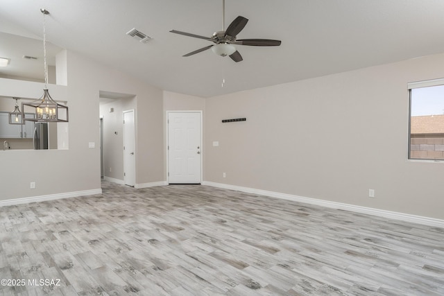1542 N Amberbrooke Ave, Tucson, AZ 85745 - unfurnished living room with a ceiling fan, light wood finished floors, baseboards, a chandelier, and high vaulted ceiling