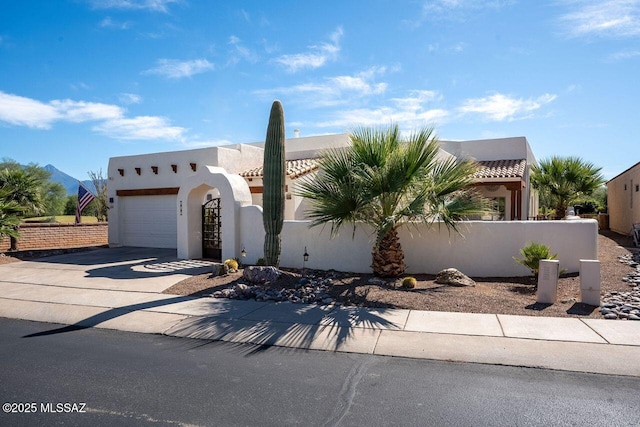 489 W Wedge Way, Green Valley, AZ 85614 - pueblo revival-style home featuring stucco siding, driveway, an attached garage, and a fenced front yard