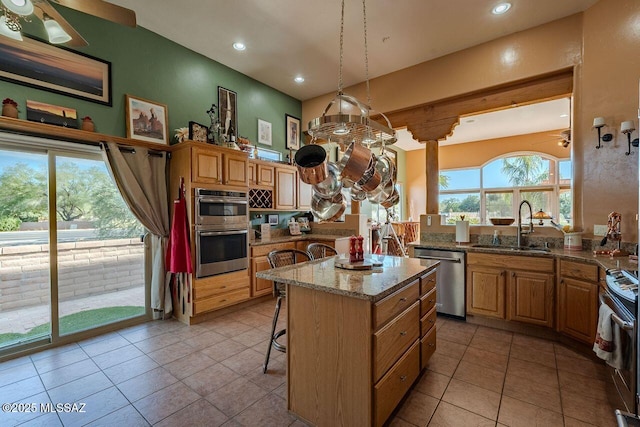 489 W Wedge Way, Green Valley, AZ 85614 - kitchen with stainless steel appliances, a sink, a kitchen breakfast bar, a ceiling fan, and light stone counters