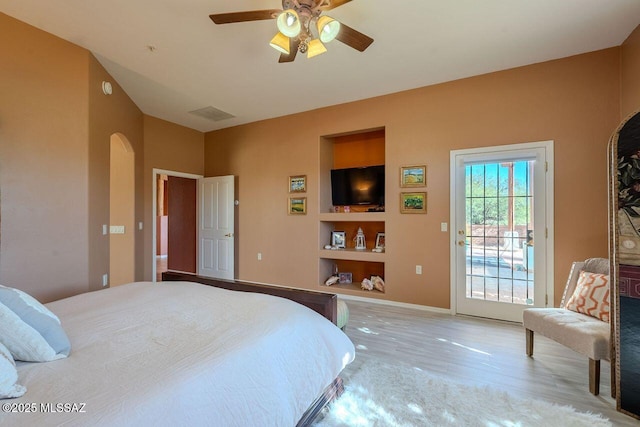 489 W Wedge Way, Green Valley, AZ 85614 - bedroom with arched walkways, access to exterior, light wood-style flooring, baseboards, and a ceiling fan