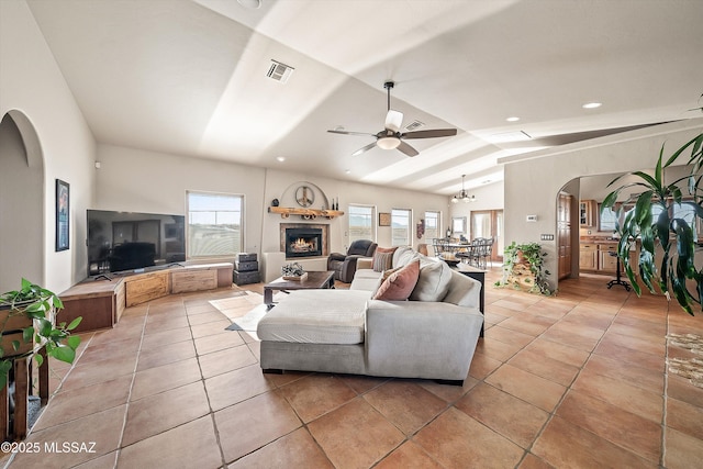 4 Mustang Trl, Sonoita, AZ 85637 - living area with arched walkways, light tile patterned floors, lofted ceiling, a lit fireplace, and a ceiling fan