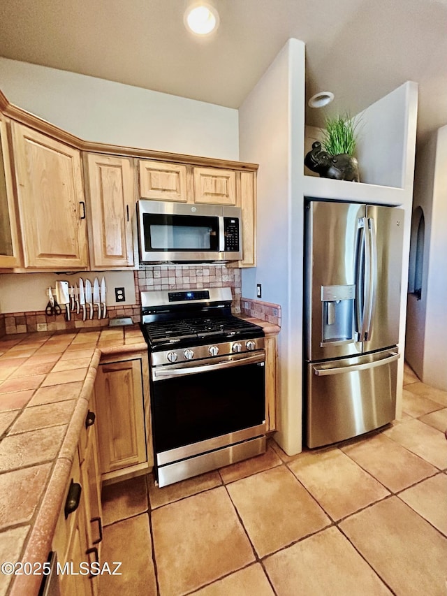 4 Mustang Trl, Sonoita, AZ 85637 - kitchen with appliances with stainless steel finishes, tile countertops, light brown cabinetry, and tasteful backsplash