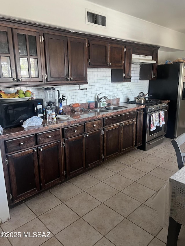 321-323 E Olive St, Tucson, AZ 85706 - kitchen with stainless steel appliances, light tile patterned floors, under cabinet range hood, and backsplash