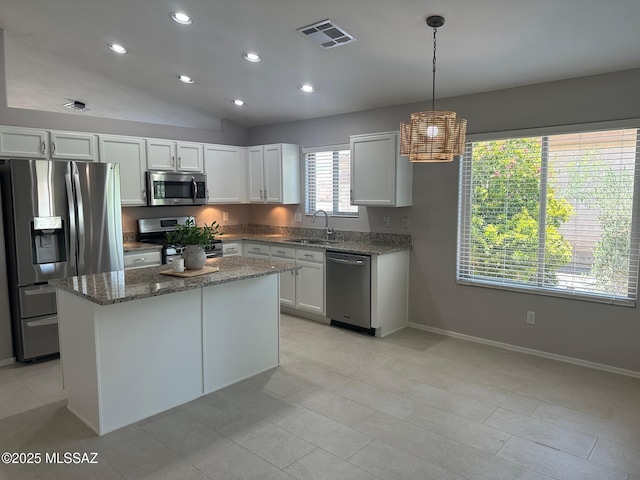 6960 W Harcuvar Dr, Tucson, AZ 85743 - kitchen featuring appliances with stainless steel finishes, a sink, stone counters, a kitchen island, and baseboards