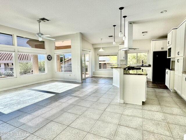 13942 N Cirrus Hill Dr, Oro Valley, AZ 85755 - kitchen with range hood, baseboards, open floor plan, a ceiling fan, and white cabinetry
