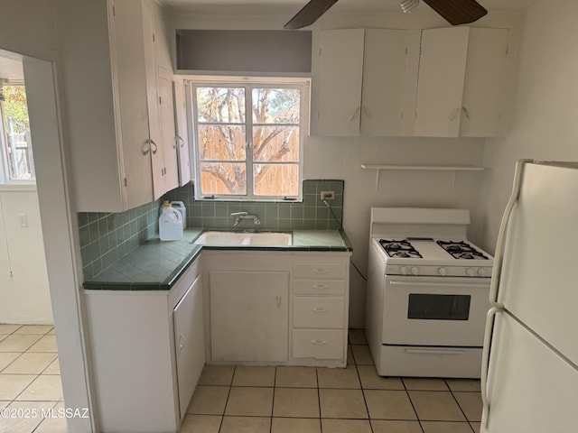 kitchen featuring tile countertops, white appliances, and light tile patterned flooring