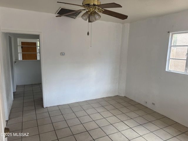 spare room with ceiling fan and light tile patterned floors